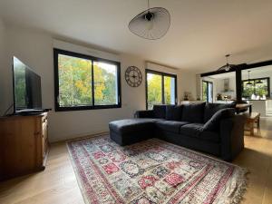 uma sala de estar com um sofá e um tapete em Les jardins de l'Hermitage em Cellettes