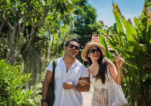 a man and a woman standing in a garden at Monaburi Boutique Resort in Rawai Beach