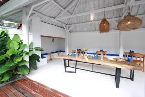 een eetkamer met een lange tafel en een plant bij The Sans Kuta Villas in Kuta Lombok