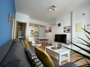 マラガにあるAmazing Apartment in the Heart of Malaga POOL & FREE PARKINGのリビングルーム(ソファ、テレビ付)