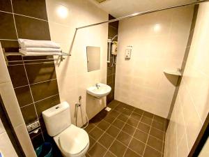 a small bathroom with a toilet and a sink at Queenspark Lovita Hotel in Melaka