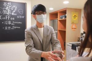 a man wearing a face mask in a coffee shop at Dream 12 Hotel in Taichung