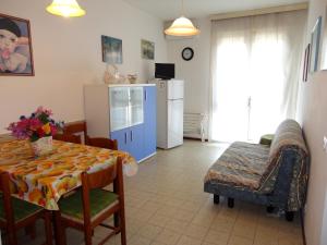 a kitchen and living room with a table and a refrigerator at Cozy flat with balcony in Caorle