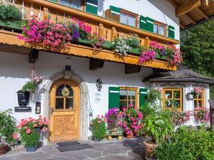 a building with flowers on the side of it at Gästehaus Oslhof Ferienwohnungen in Ramsau