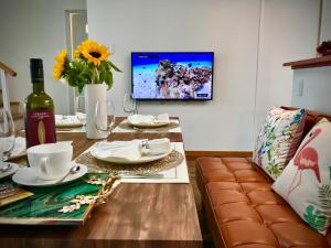 a living room with a table with a couch and a tv at Sunset Beach Vacation House in Chatan
