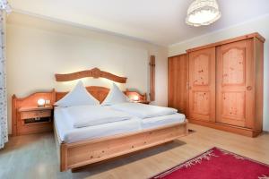 a bedroom with a large bed with a wooden headboard at Gästehaus Oslhof Ferienwohnungen in Ramsau +23 photos