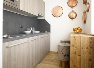 una cucina con armadi in legno e un cesto di frutta su un bancone di Ciasa Mancin Suite-Apartments a Moena Altre 20 foto