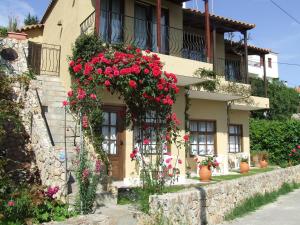 a building with flowers on the side of it at Dawn's Rooms in Patitiri