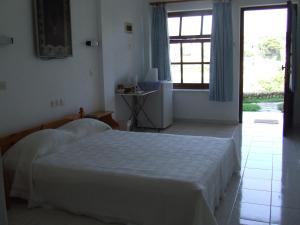 a bedroom with a white bed and a window at Dawn's Rooms in Patitiri