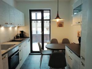 cocina con mesa, sillas y ventana en Ferienwohnung Ahrens en Hoyerswerda