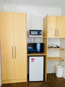 
a small kitchen with a microwave and a dishwasher at Barossa Gateway Motel in Nuriootpa
