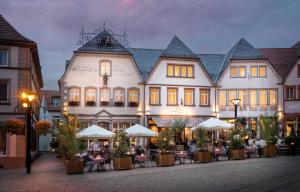 ザンクト・ヴェンデルにあるAngel's - das hotel am fruchtmarktのテーブルと椅子が前に置かれた大きな建物