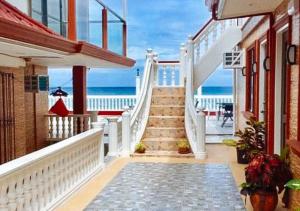 un escalier menant à un balcon avec vue sur l'océan. dans l'établissement RedDoorz Plus Billy's Resort Oslob, à Oslob