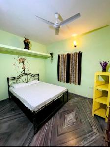 Schlafzimmer mit einem Bett und einem Deckenventilator in der Unterkunft 4BHK Private Farm House for Budget Group stay in Mandrem