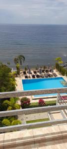a pool with chairs and the ocean in the background at Ocean Resort Amed in Amed