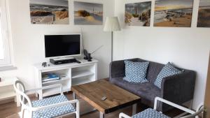 ein Wohnzimmer mit einem Sofa und einem Tisch in der Unterkunft Bungalow im Erlengrund in Rostock