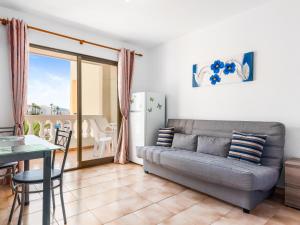 a living room with a couch and a table at 651 Bright establishment, heated pool and Wi Fi in Los Cristianos