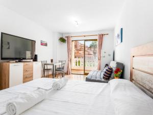 a bedroom with a large white bed and a television at 651 Bright establishment, heated pool and Wi Fi in Los Cristianos +17 photos