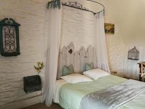 1 dormitorio con 1 cama con dosel en Bayeux - Domaine Le Vivier, en Castillon