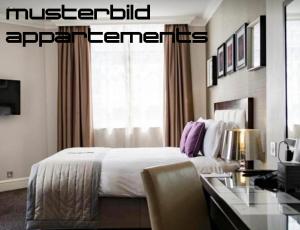 a hotel room with a bed and a desk with a desk at Sandbank Hotel & Appartements Lubmin in Lubmin