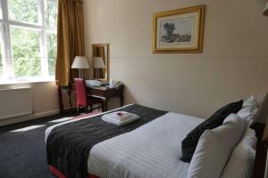 Postel nebo postele na pokoji v ubytování Broadfield Park Hotel