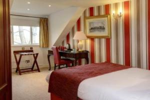 um quarto de hotel com uma cama, uma secretária e uma mesa em Broadfield Park Hotel em Rochdale