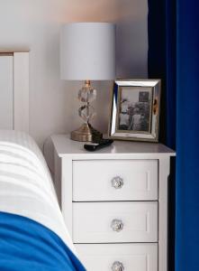 einem Nachttisch mit einer Lampe und einem Bild darauf in der Unterkunft Pension Engel in Grifte