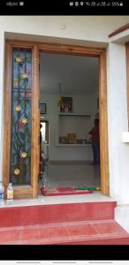 Una puerta de un edificio con una ventana con flores. en Kodai sakthi guest house, en Kodaikanal 19 fotos más