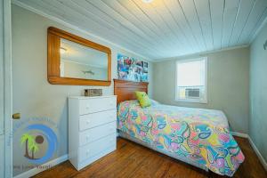 a bedroom with a bed and a dresser and a mirror at Oceanfront Ocean Drive Cottage in Myrtle Beach