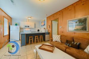 Una sala de estar con un sofá y una cocina. en Cg Beach Bungalow #3, en Myrtle Beach