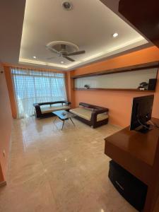 a living room with a couch and a tv at GLORY BEACH RESORT NICE SEAVIEW HIGH STANDARD 3 BEDROOM in Port Dickson