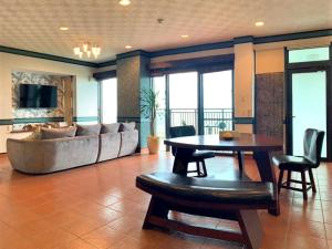 a living room with a couch and a table and chairs at Haruhoo Resort ISHIGAKI in Ishigaki Island