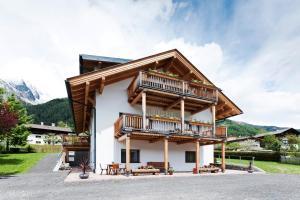 uma casa nas montanhas com varandas de madeira em Bacher Ferienwohnungen em Virgen