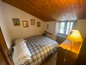 ein Schlafzimmer mit einem Bett, einer Lampe und einem Fenster in der Unterkunft Roccaraso in tasca in Roccaraso