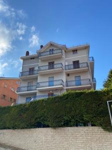 a tall white building with balconies on top of a wall at Roccaraso in tasca in Roccaraso