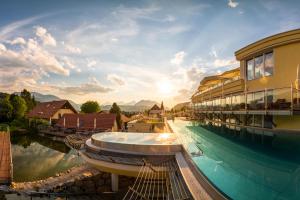 a luxury resort with a boat in the water at Dilly - Das Nationalpark Resort in Windischgarsten