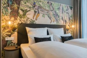 a hotel room with two beds and a painting on the wall at NinetyNine Bergedorf in Hamburg