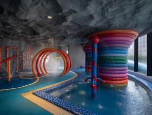 una sala giochi con piscina e scivolo d'acqua di JHL Solitaire Gading Serpong a Serpong