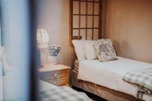 a bedroom with a bed and a table with a lamp at Sorgenfri in Hendrina