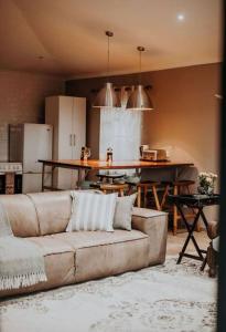 a living room with a couch and a kitchen at Sorgenfri in Hendrina