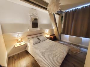 1 dormitorio con 1 cama, 2 lámparas y ventana en "Le Rive-Gauche" appartement tout équipé, 2 chambres à 2 pas de la gare -- WiFi - TV connectée, en Châlons-en-Champagne