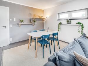 a table and chairs in a living room with a couch at limehome Montabaur Am Quendelberg in Montabaur