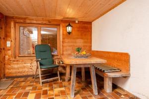 Habitación de madera con mesa de madera y silla verde. en Wilder Kaiser, en Reit im Winkl