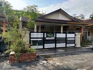 a house with a black and white fence at Ubaid Homestay in Seremban