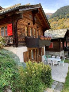 uma casa com uma mesa e cadeiras em frente em Chalet Leonie LE0 em Blatten bei Naters