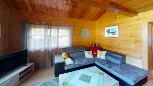 a living room with a couch and a television at Chalet Leonie LE0 in Blatten bei Naters