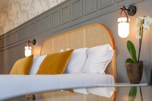 
a white bed sitting under a lamp in a room at Puente Colgante Boutique Hotel in Portugalete

