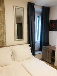 a bedroom with a white bed and white curtains at Centro di Centri Rooms in Split