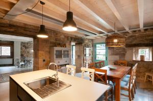 eine Küche und ein Esszimmer mit einem Waschbecken und einem Tisch in der Unterkunft La Casa de Piedra in Herrera de Ibio
