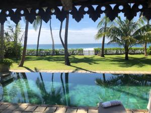 a view of the ocean from a resort swimming pool at Samudra Beach House in Habaraduwa Central